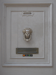 908464 Afbeelding van twee liggende metalen brievenbussen in een paneel met een deurklopper, in de voorgevel van het ...